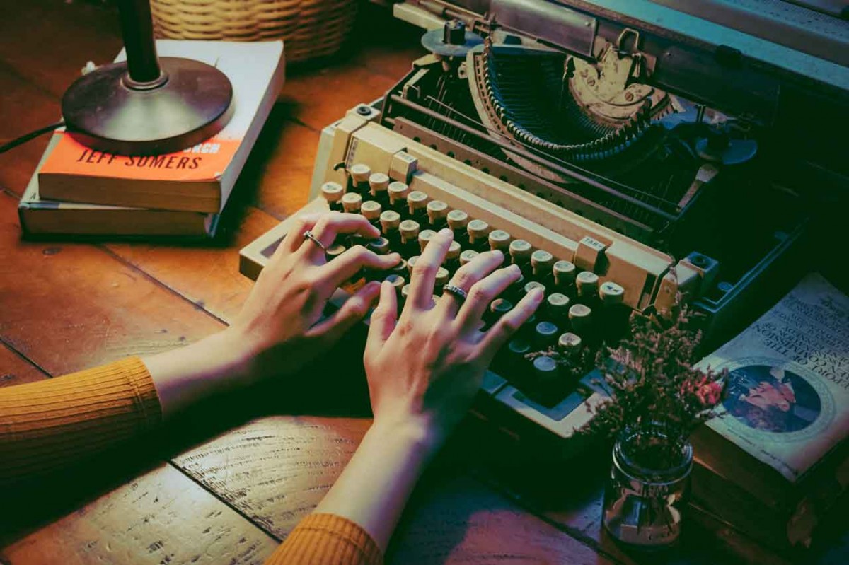 A writer uses her stylish antique typewriter to work on a freelance writer project in this file photo.